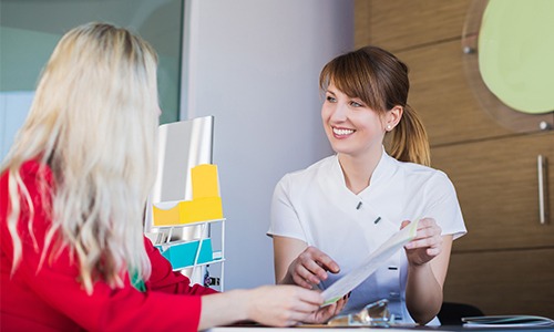 Dental team member showing patient forms