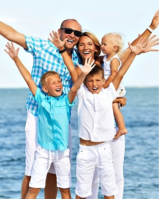 Family of five smiling on the beach