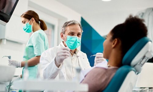 Emergency dentist smiling at patient before dental exam