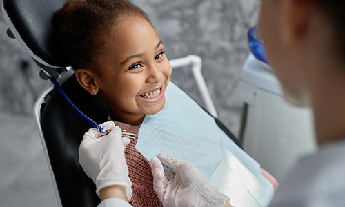 Child smiling at dentist after getting dental sealants