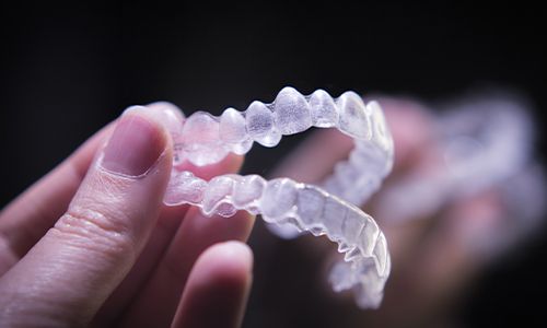 Hand holding teeth whitening application trays