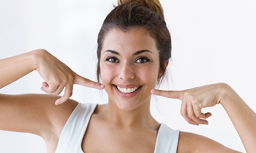 Woman pointing to smile