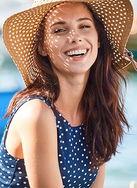 Woman wearing a sunhat and blue blouse outdoors