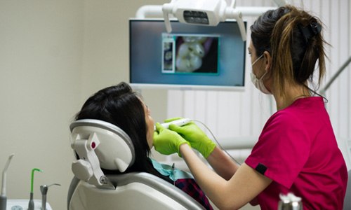 a dental hygienist using an intraoral camera on a patient