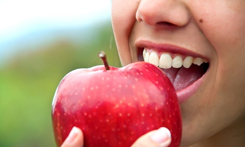 Woman taking a bite into an apple