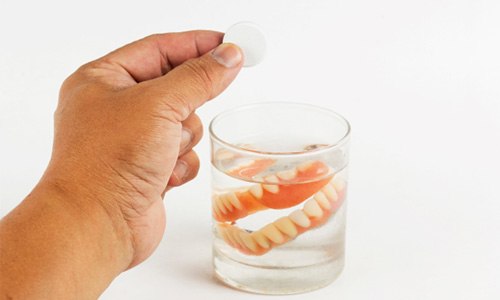 Dentures soaking in a glass