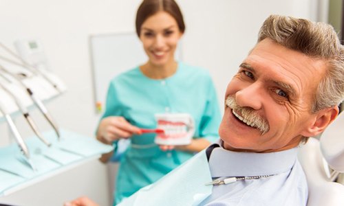 older man talking to his dentist about dentures near Marathon 