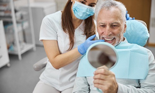 patient smiling in dental mirror 