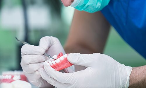 A closeup of a full denture against a blue background