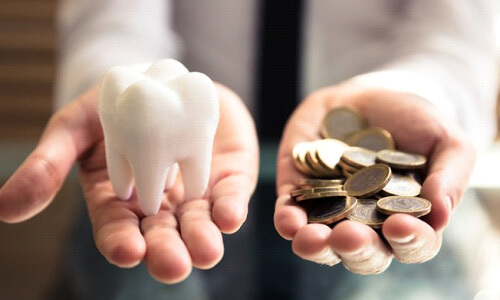 A tooth balanced with a pile of coins