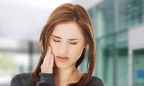 Woman in pain holding jaw