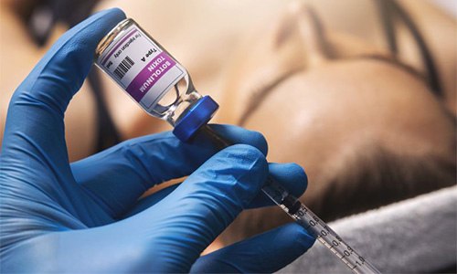 Gloved hand preparing BOTOX injection