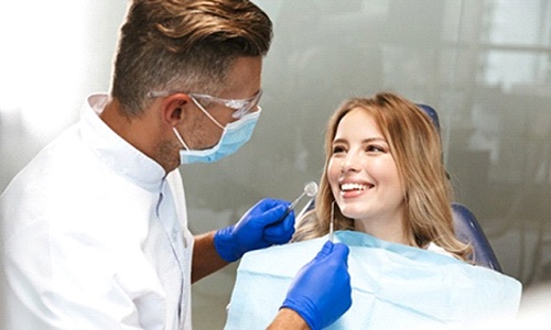 A female patient listens closely as her dentist prepares to examine her smile and explain how dental implants work in Big Pine Key