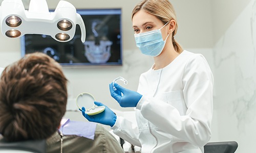Dentist showing patient clear aligner in treatment room