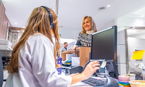 Smiling woman talking to dental receptionist