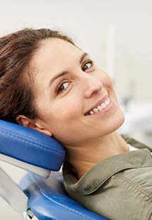 Smiling woman leaning back in dental chair