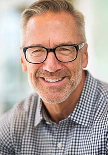 Older man in plaid shirt smiling