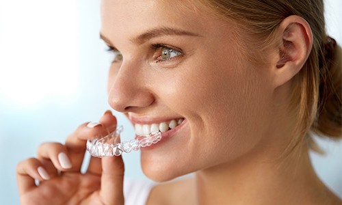 Woman placing Invisalign tray