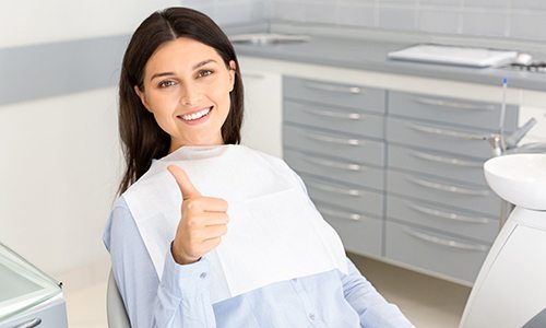Happy dental patient making thumbs up gesture
