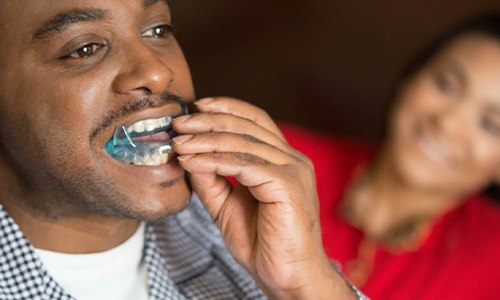 Man placing sleep apnea appliance