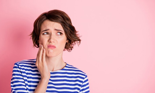 Woman rubbing her aching jaw