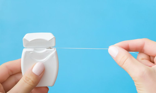 Patient pulling on a string of dental floss