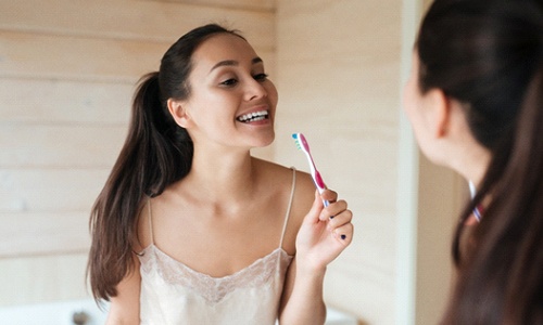 Woman with veneers in Big Pine Key brushing her teeth