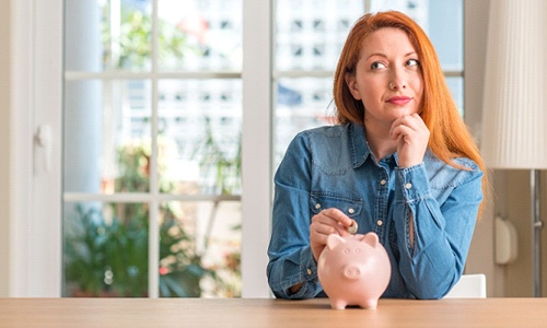 Woman putting coin in piggy bank