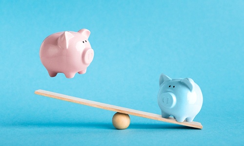 Piggy banks on balance scale