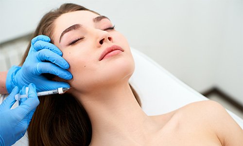 Woman receiving dermal filler injection along her jawline