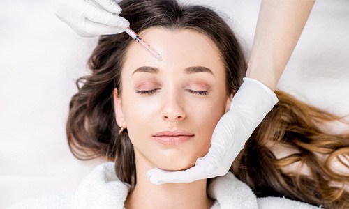Woman relaxing while receiving BOTOX injection in her forehead