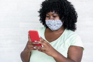 person calling their dentist in Big Pine Key to schedule an appointment while wearing a mask