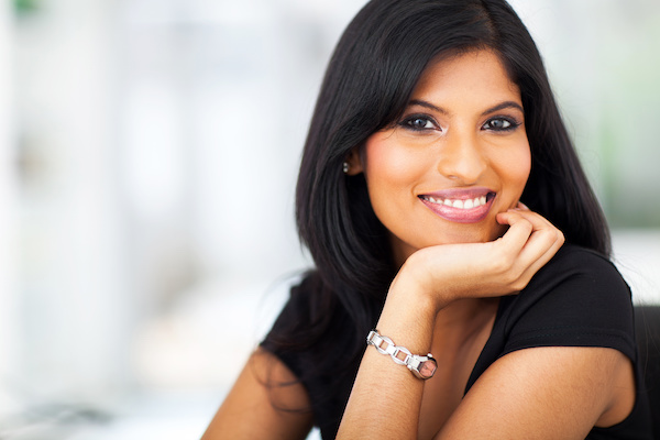 portrait of a woman with dark hair smiling, blurred background