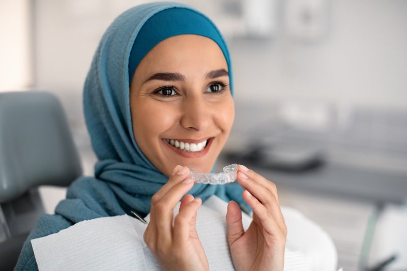 Patient putting on their Invisalign aligner