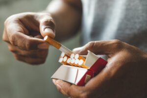 Person pulling a cigarette from its pack. 